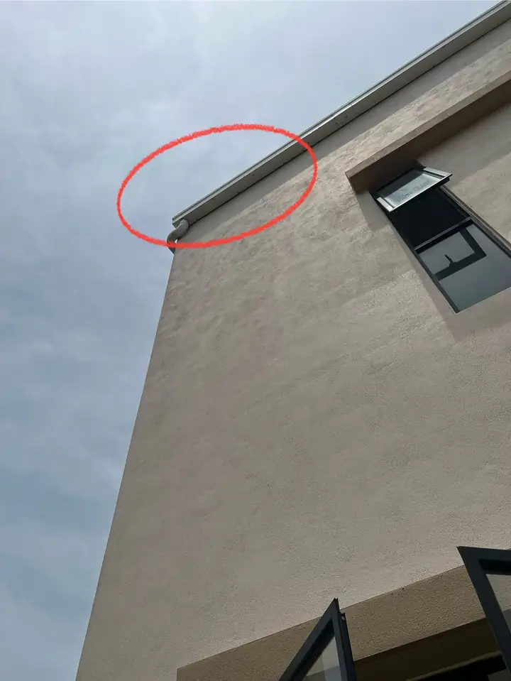 Blocked roof gutter seen from below, circled in red