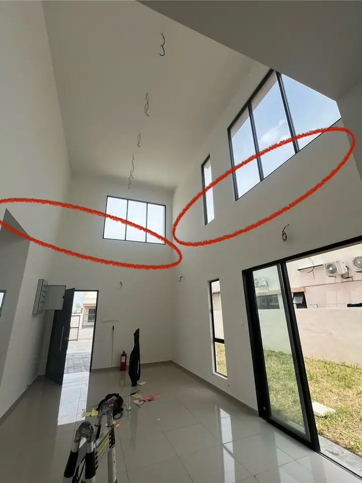 Cracks high on the walls of a double-height living hall, circled in red