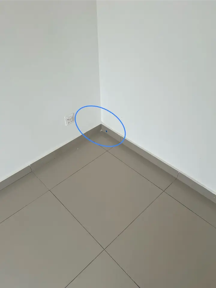 Hollow skirting tile at a bedroom corner, circled in blue